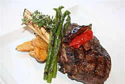 This Coffee-Rubbed Bone-In Rib Eye Steak is complete with roasted fingerling potatoes, green asparagus and a merlot reduction - just one of the mouthwatering options on Vines
