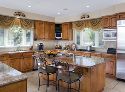 The heavy use of lightly-stained maple, reflected in the shiny stainless steel appliances, gives the gourmet kitchen a warm aura.  The tropical fruit tray was selected from Ma Maison.