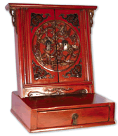 The mirror cover of this red lacquer makeup stand with drawer is decorated with a deer and crane surrounded by pine branched and flowers, with a bat in each corner