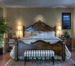 The distressed handmade antique French bed is the focal point of the master bedroom. "I love the dark brown color," says Carr.
