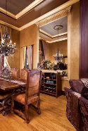 Studded Spanish cowhide-covered dining chairs combine rustic texture with dramatic height in the formal dining room.