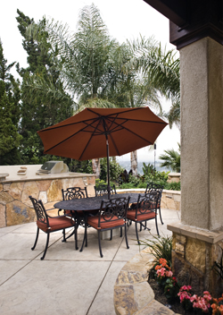Darkly-shaded scroll work, combined with rust-colored weather-resistant fabric coverings, suggest a Mediterranean theme. The patio set was purchased from Oasis Garden & Patio.